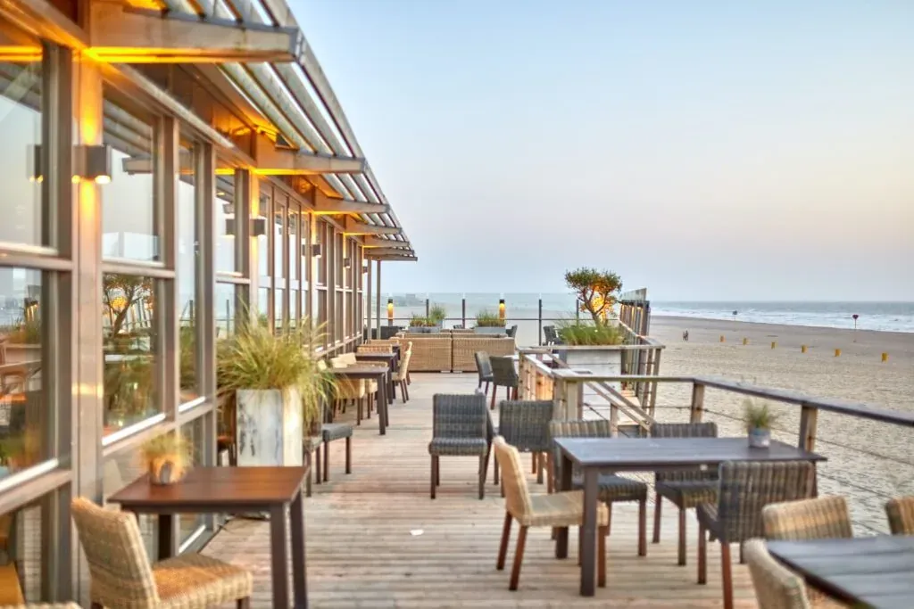 Spacious beachfront restaurant terrace with rows of tables