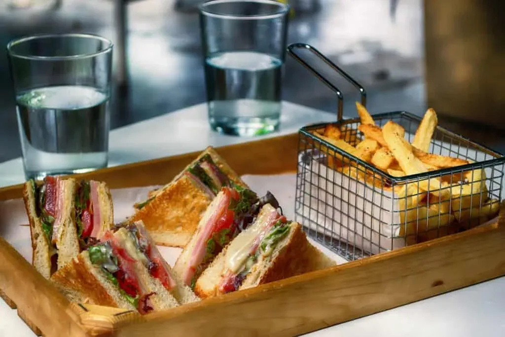 Club sandwich with fries and water served at a sandwich bar
