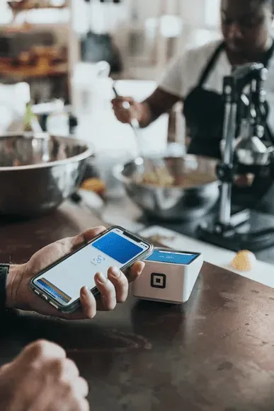 Guest at a restaurant using a contactless payment option to pay.