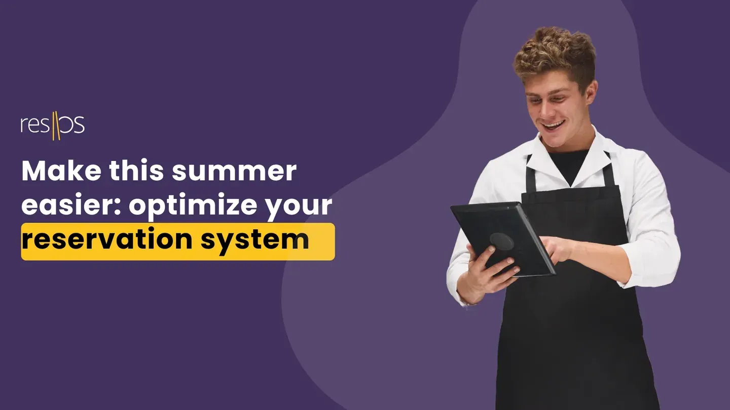 Smiling waiter in an apron using a tablet to manage reservations